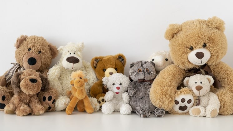 Group of assorted teddy bears and plush animals in various sizes and colors sitting against a white background.
