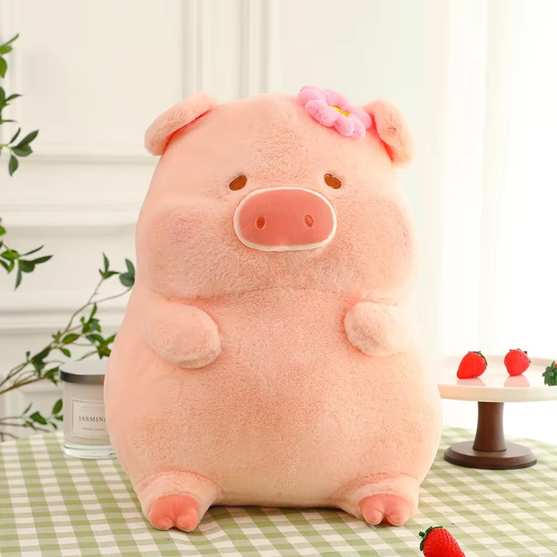 A cute, chubby pink plush pig with a flower on its head sitting on a checkered tablecloth, surrounded by strawberries and soft decor.