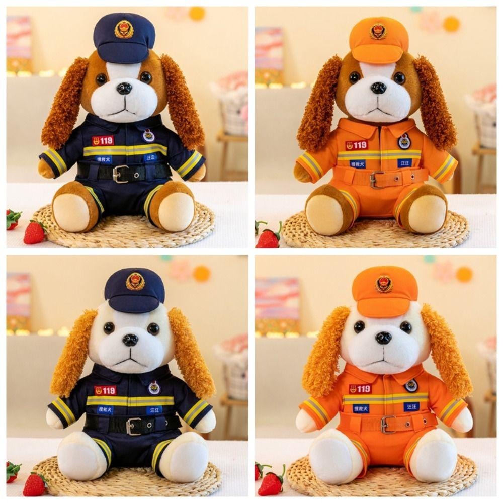 Four plush dog toys dressed in firefighter and emergency uniforms, with two in navy blue and two in orange, each featuring a matching cap and official-looking patches.