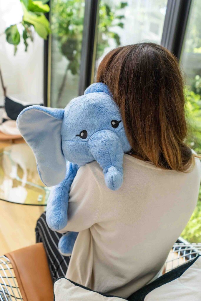 Woman hugging soft blue elephant plush toy