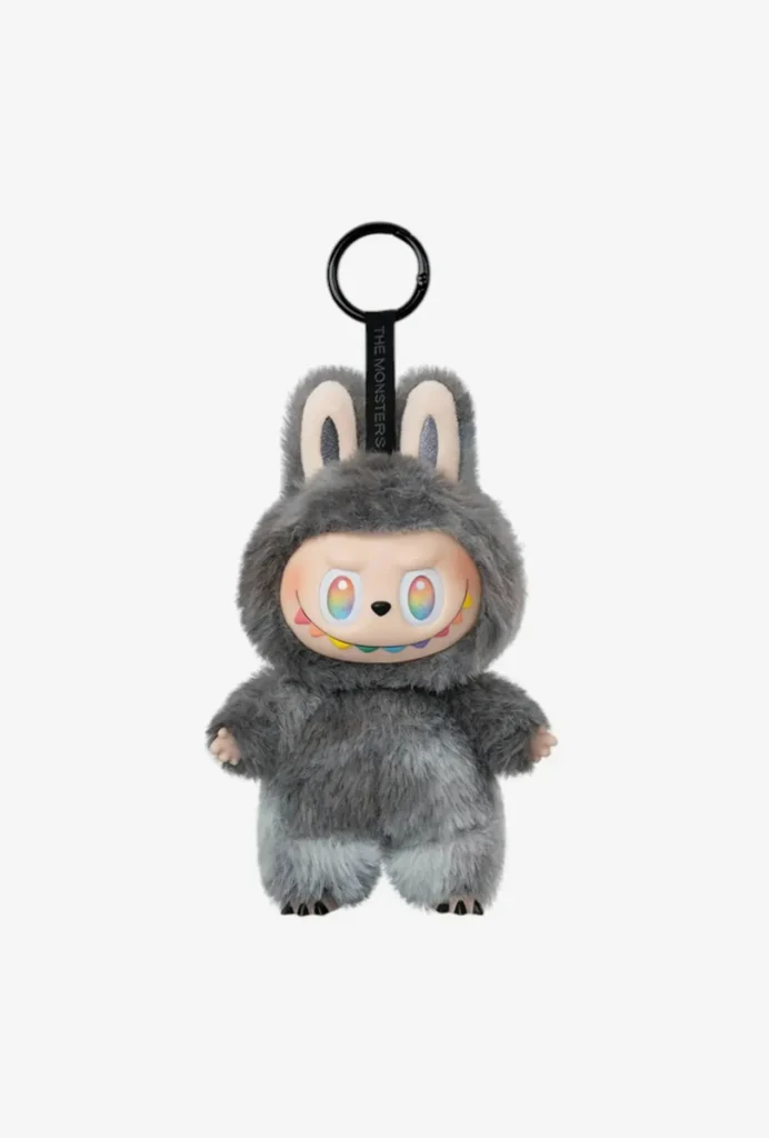 Gray furry monster plush keyring with colorful eyes and rainbow smile.