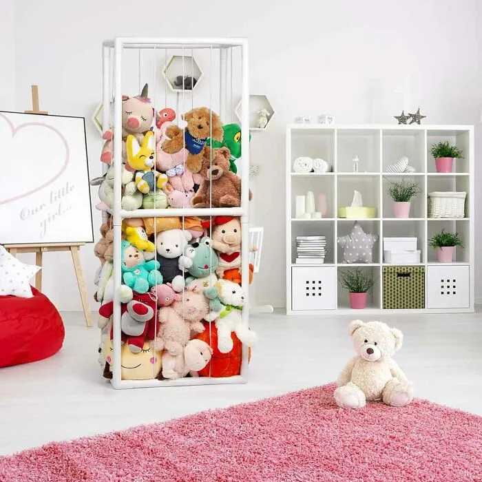 White rack filled with various stuffed animals in a kids' room.