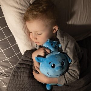 Boy cuddling blue plush toy in bed