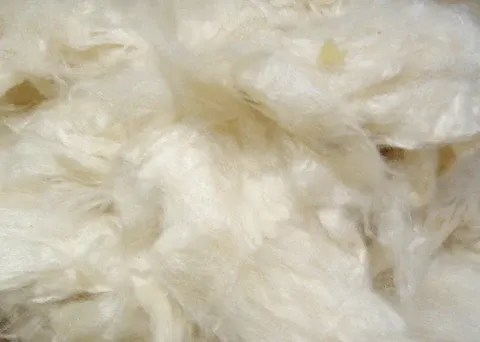 Primo piano di una soffice fibra sintetica bianca, comunemente utilizzata come materiale di riempimento per peluche e cuscini.