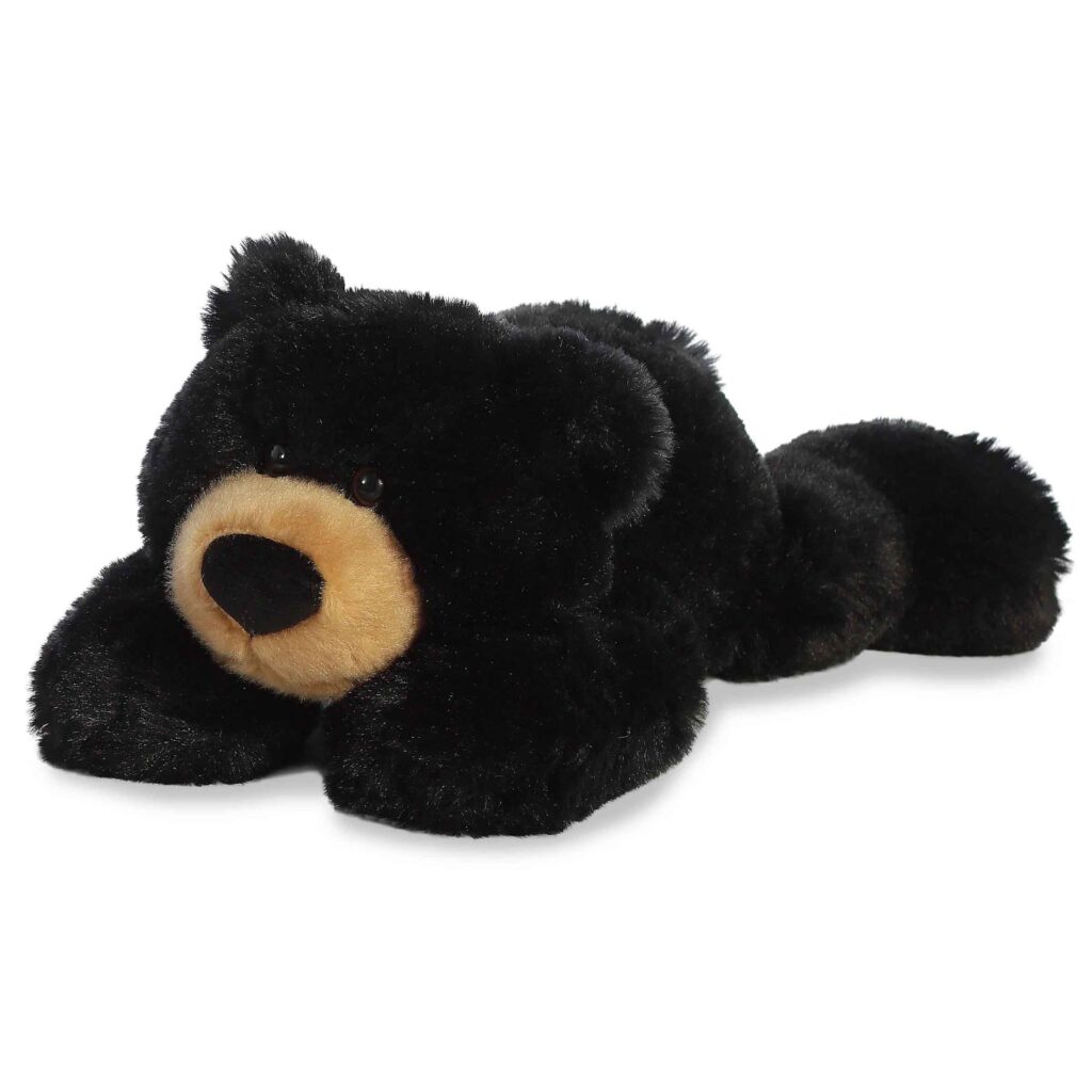 Orso nero di peluche sdraiato con muso abbronzato e morbida pelliccia di peluche