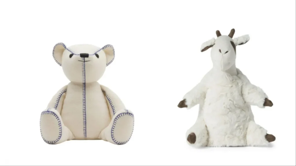 Cream-colored plush bear with stitched details and white plush goat with brown spots