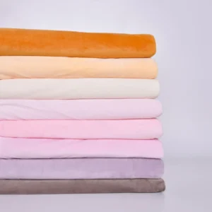 Stack of soft pastel-colored fabrics in orange, cream, pink, purple, and gray hues
