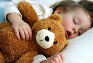 Child sleeping with teddy bear
