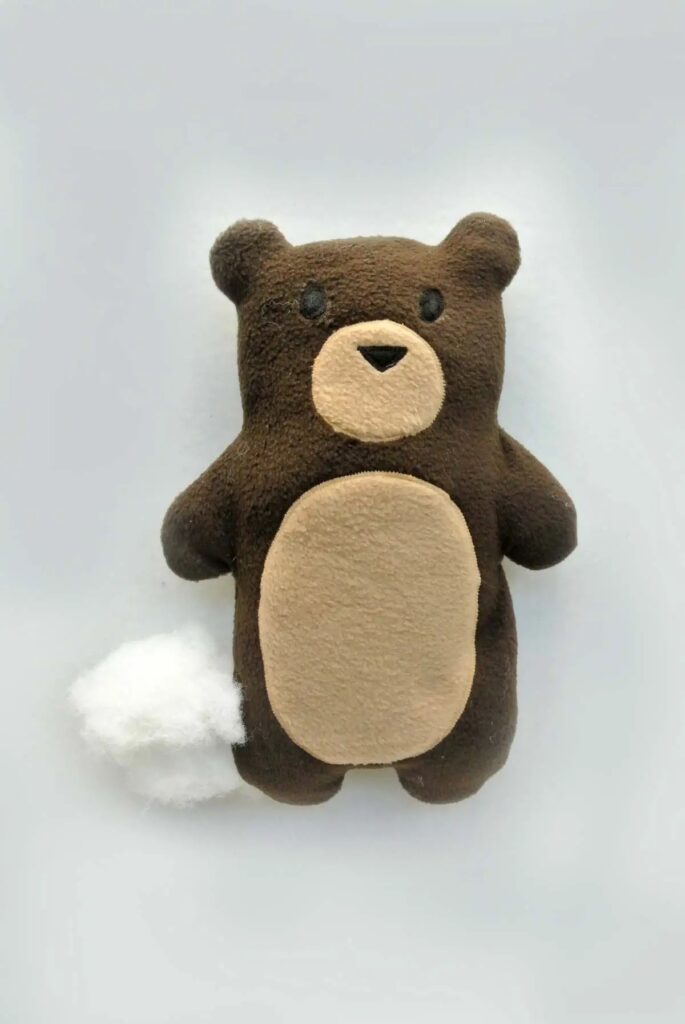 Orso di peluche marrone con imbottitura in uscita
