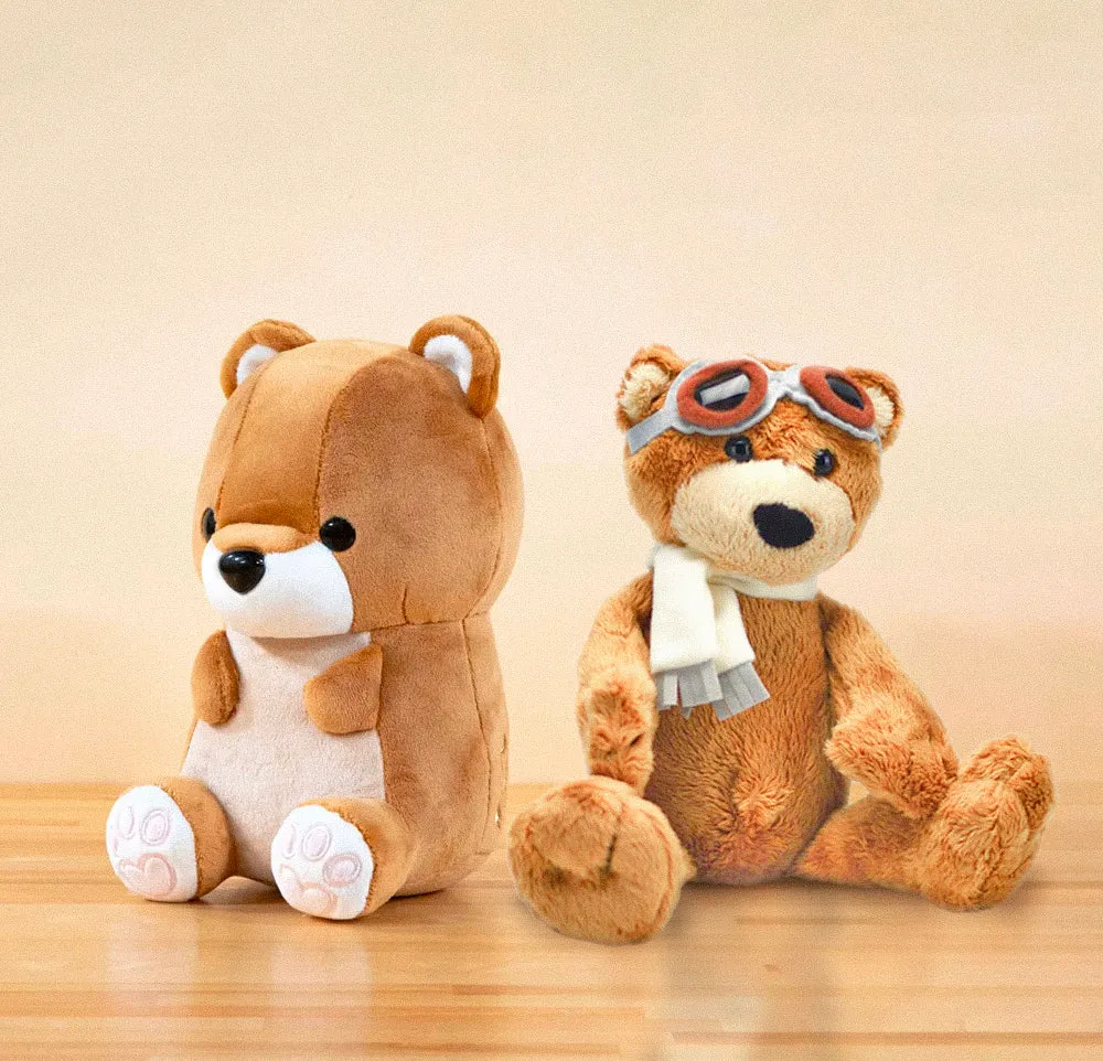 Two plush bear toys sitting on wooden surface against beige background.