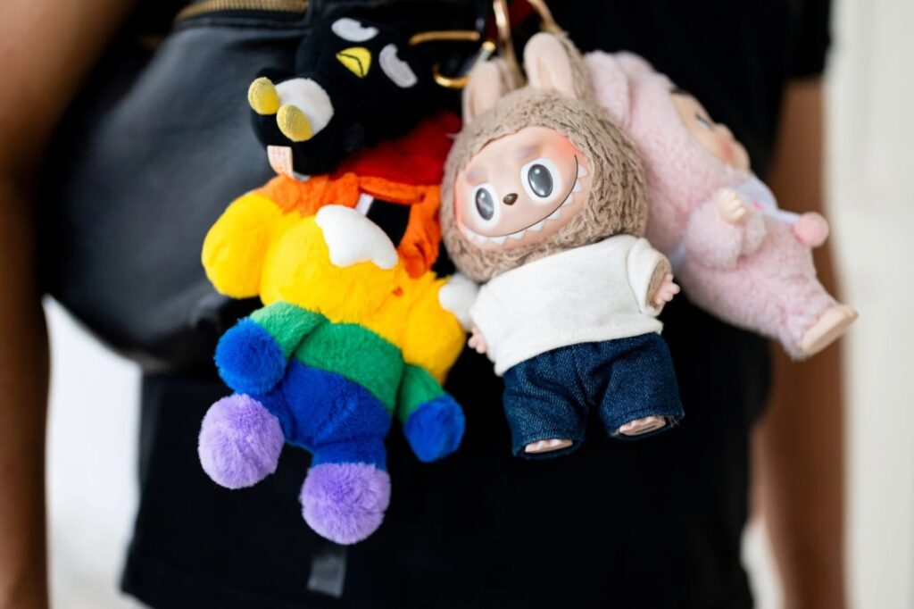 Colorful plush keychains hanging from a bag