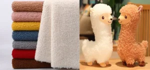 Stack of sherpa fabric and two plush alpaca toys standing on a table