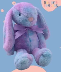 Soft purple and blue plush bunny with floppy ears and a purple ribbon.