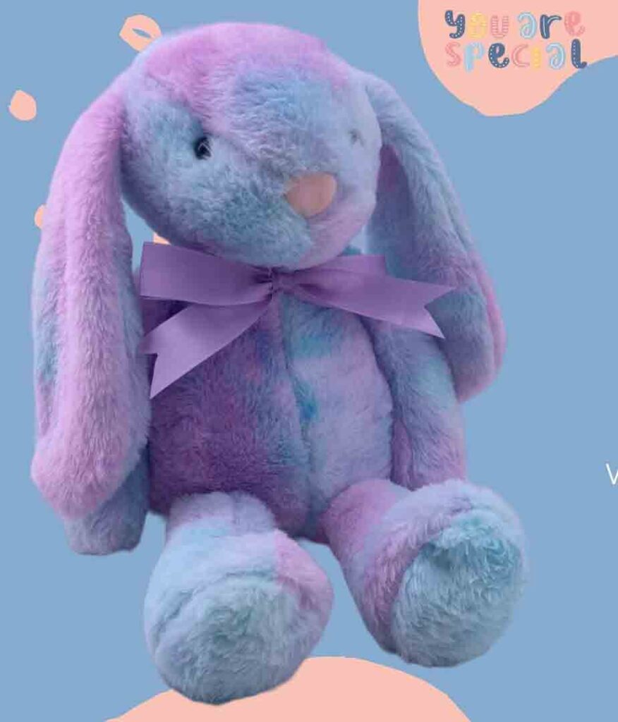 Soft purple and blue plush bunny with floppy ears and a purple ribbon.