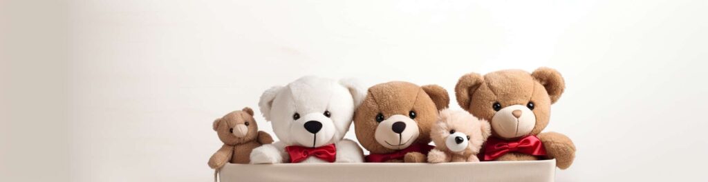 Una collezione di orsacchiotti di peluche di diverse dimensioni e colori, tutti collocati in un contenitore beige su uno sfondo a tinta unita.