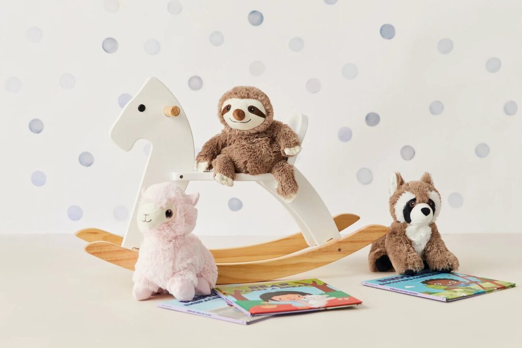 Sloth, raccoon, and alpaca plush on rocking horse