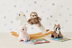 Sloth, raccoon, and alpaca plush on rocking horse