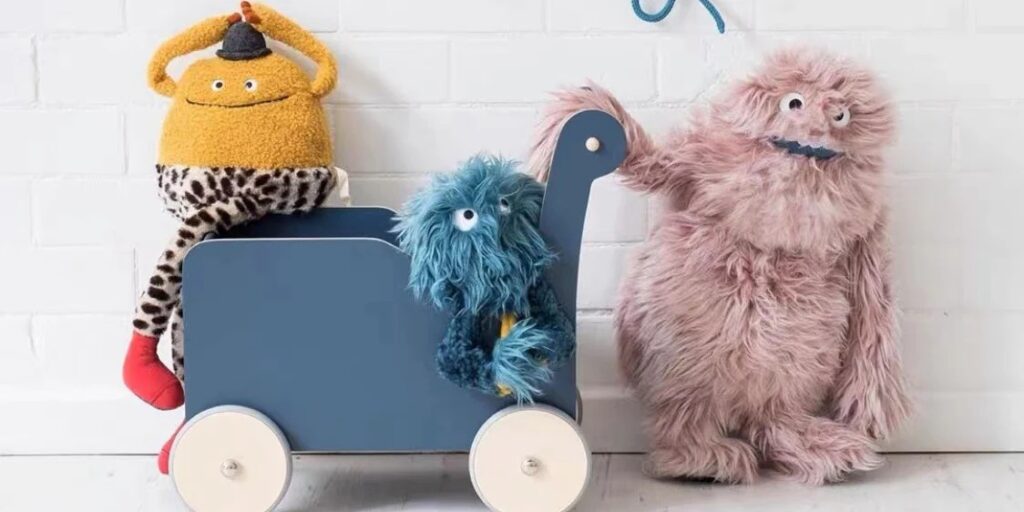 Three colorful and fuzzy monster plush toys in playful poses