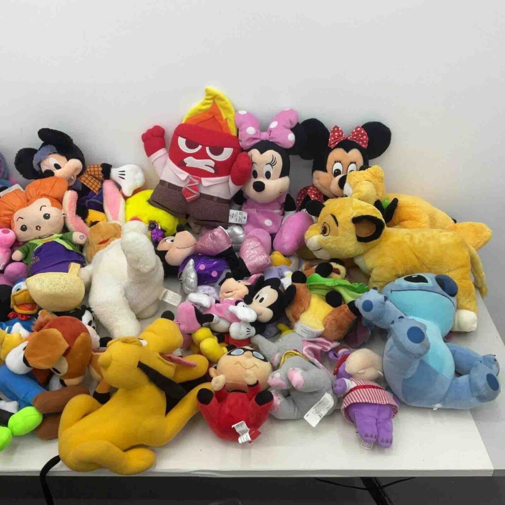 Various plush toys piled on white table