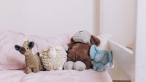 Various plush toys on a pink bedspread