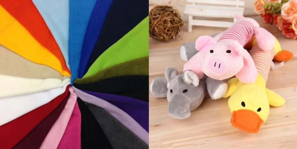 Colorful fleece fabric swatches and soft animal plush toys on wooden surface.