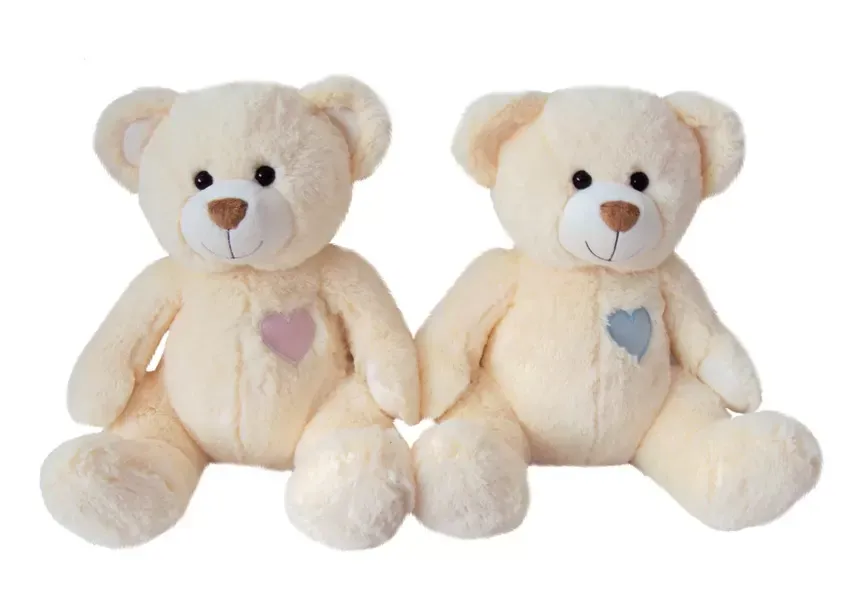 Two cream teddy bears with heart patches on chest.