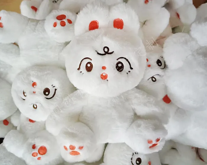 Soft white bunny plush toys with orange details.