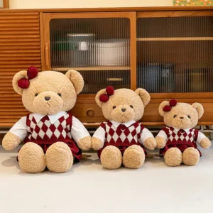 Three teddy bears wearing matching red and white outfits with bows.