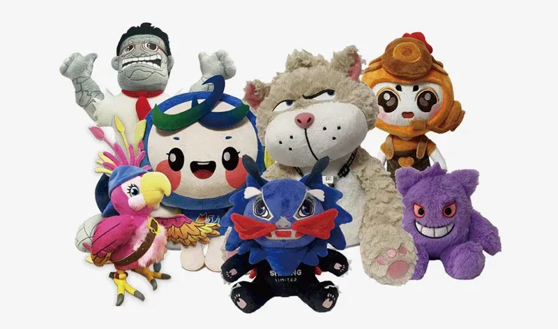 Group of diverse colorful plush toys including animals and cartoon figures on white background.