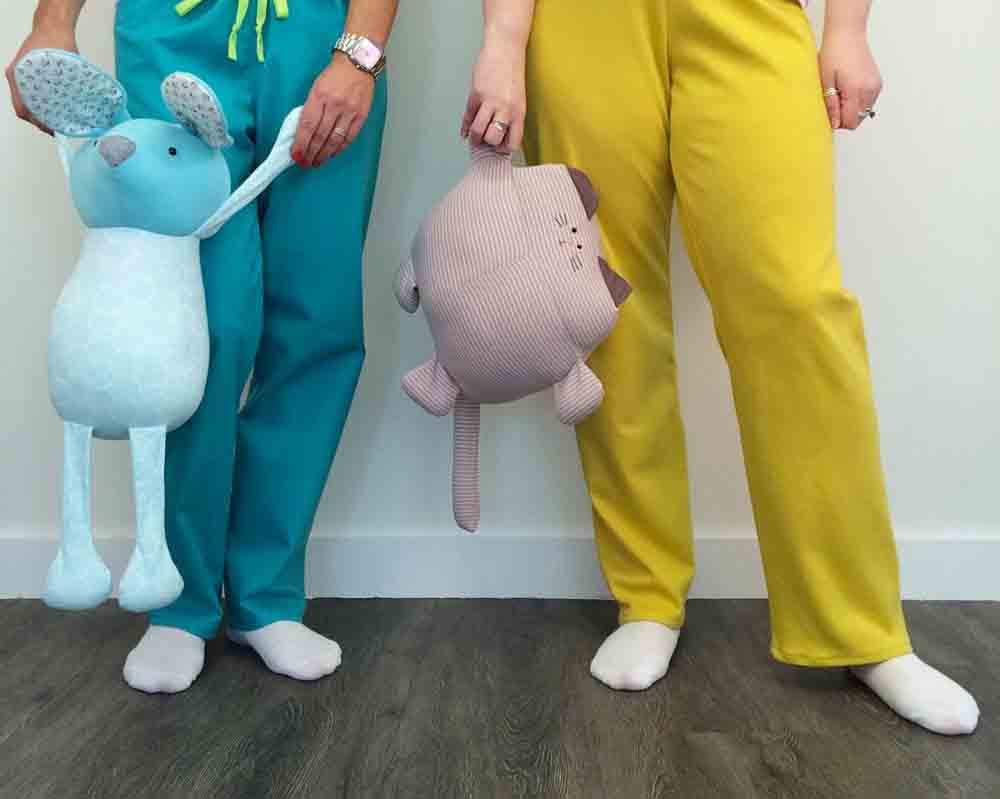 People holding soft knitted toys.