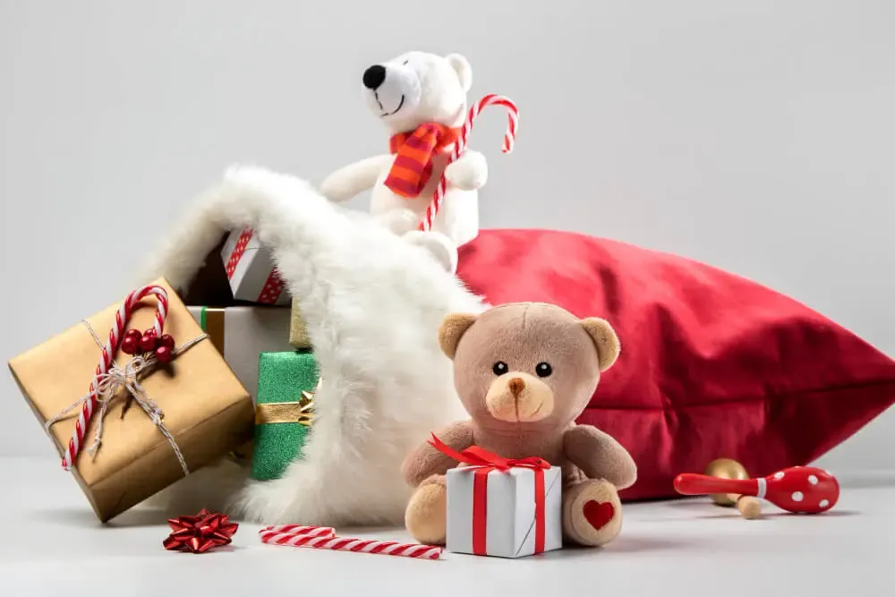 Stuffed bears and presents spilling from Santa Claus bag.