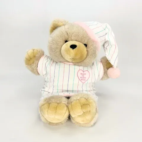 Plush teddy bear wearing striped pajamas and nightcap