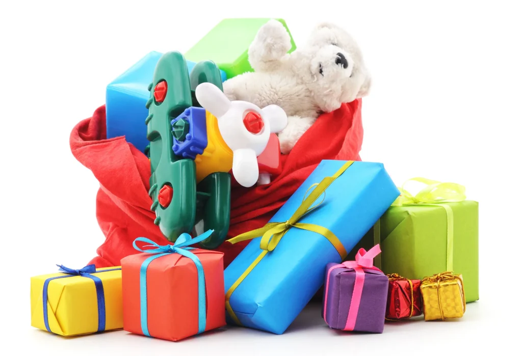 Colorful wrapped gifts with toys including teddy bear and airplane on white.