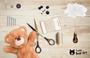 Craft tools and materials including scissors, thread, needles, stuffing, and safety eyes with plush teddy bear on wooden surface.