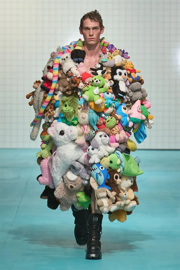 Man wearing coat covered with colorful plush toys