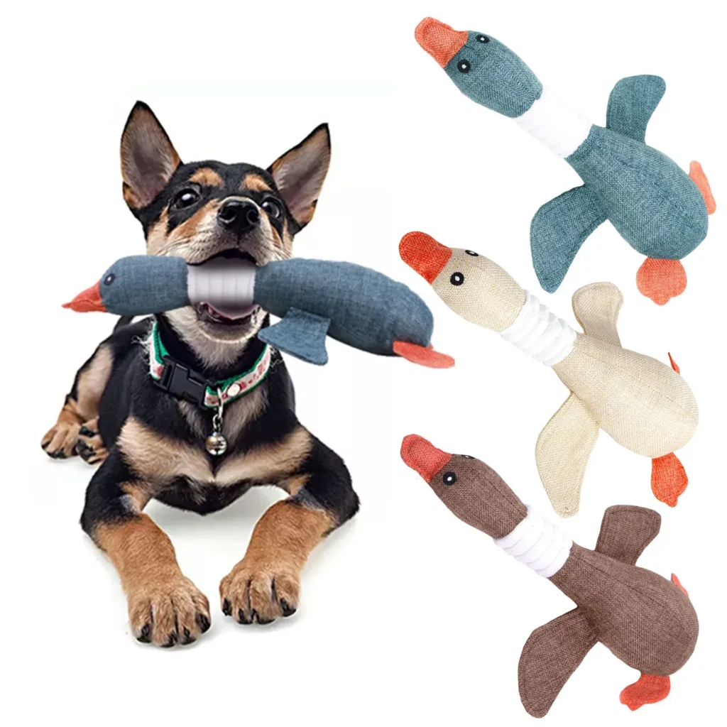 Dog holding a fabric duck chew toy in mouth.