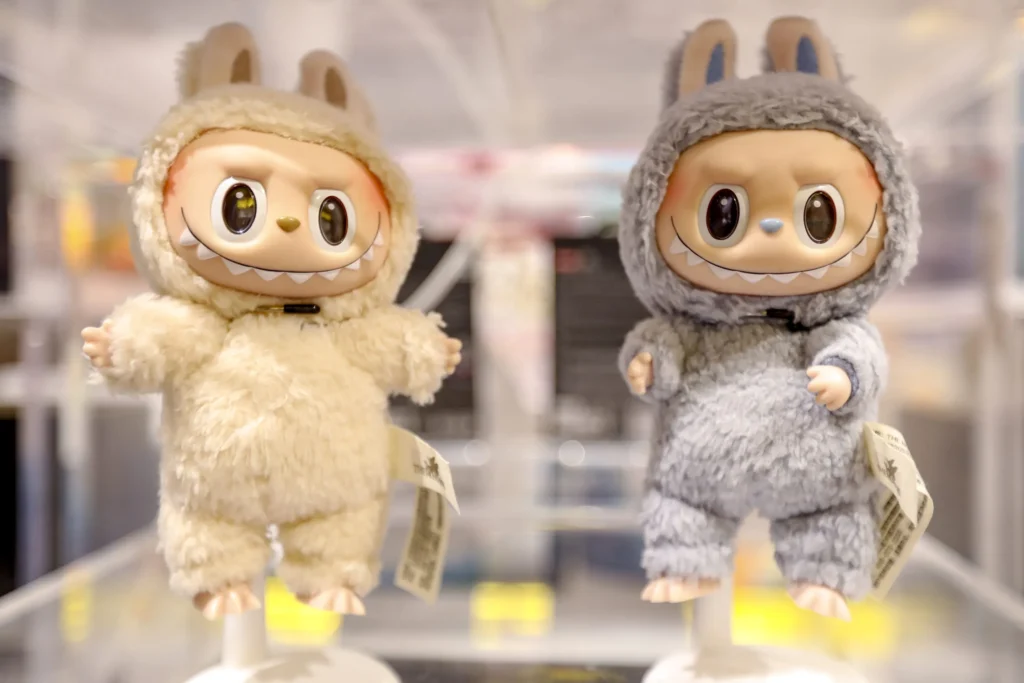Two furry monster dolls with big eyes and sharp teeth