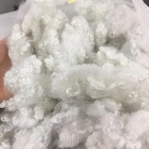Close-up of soft white synthetic fiber with curly texture.
