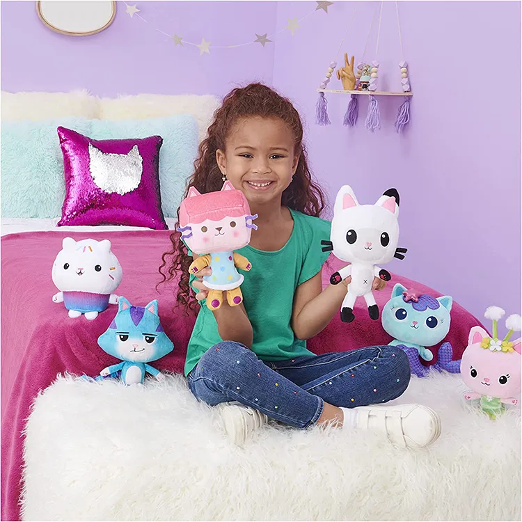 Girl sitting with colorful cat plush toys on white furry rug.