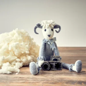 Handmade wool stuffed sheep toy with fleece on wood table