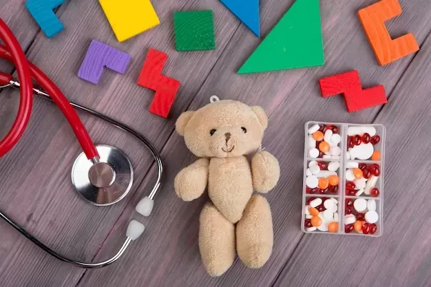 Teddy bear with stethoscope and pills on wooden floor
