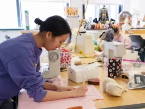 Woman drawing toy pattern in workshop