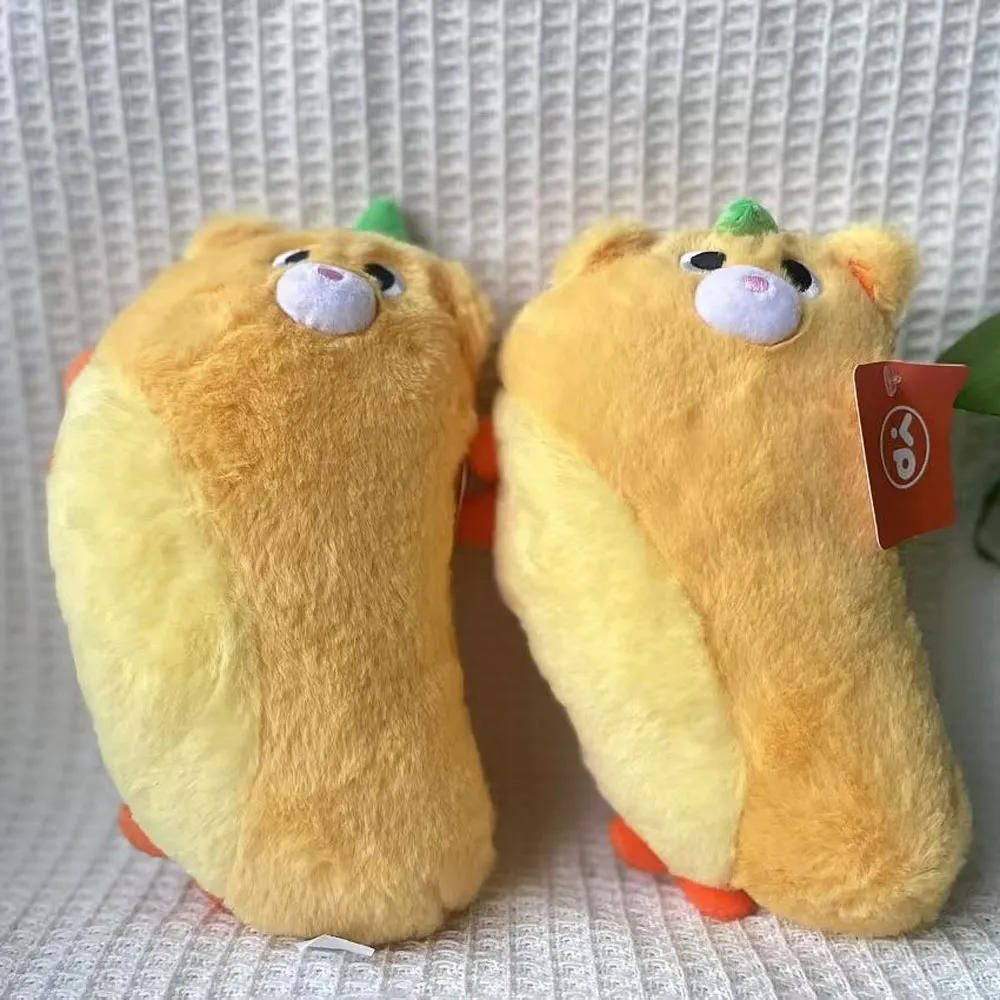 Two yellow mango-shaped plush toys with puppy faces on a textured white surface.