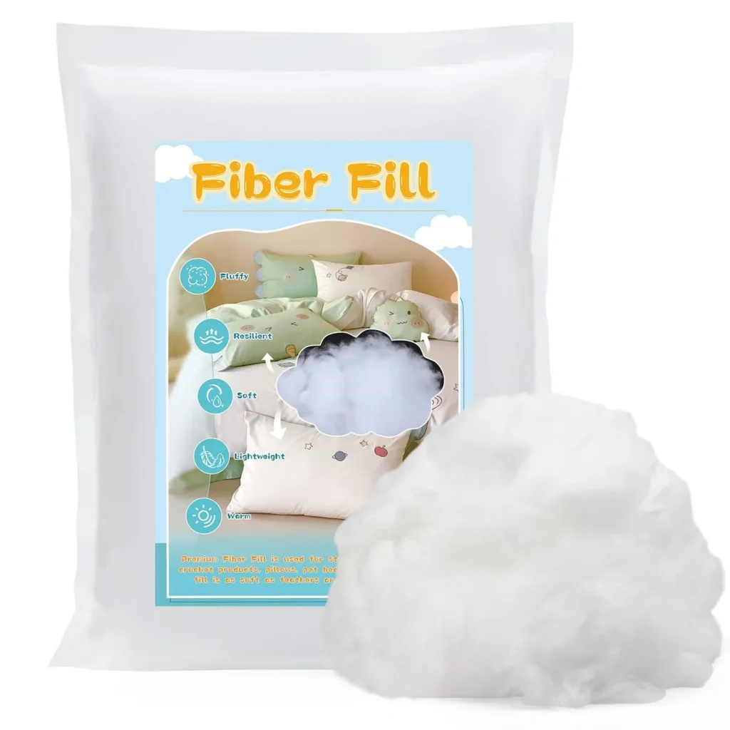 Clear bag of fiber fill stuffing with loose fiber next to it on white background.