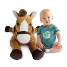 Baby sitting beside a large brown horse stuffed animal with white face markings.
