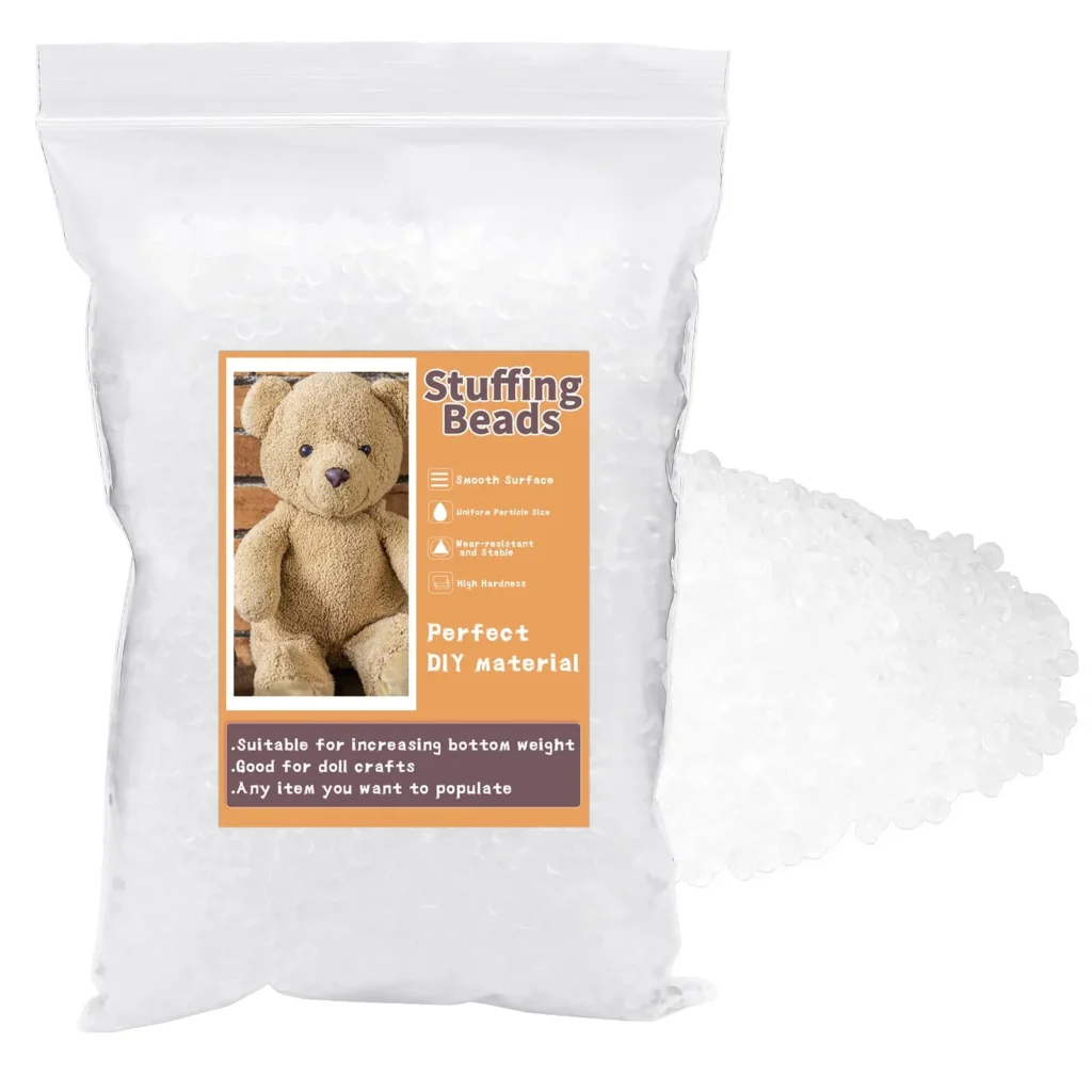 Clear bag of stuffing beads with a label showing teddy bear, next to loose beads.