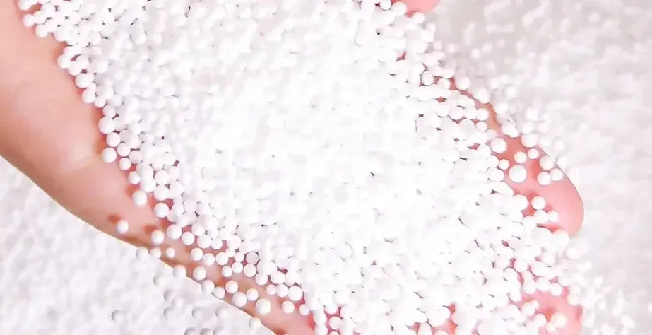 White polystyrene beads for plush toy stuffing in a person's hand