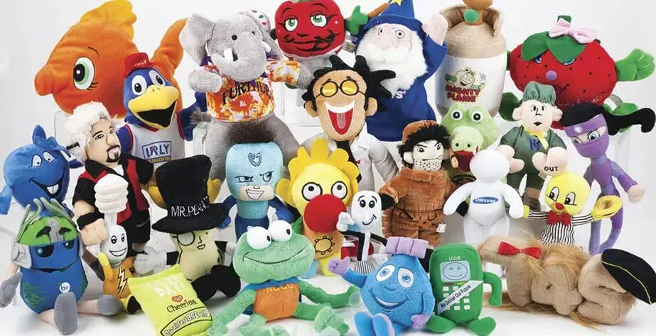 Colorful collection of various plush toys including animals, characters, and mascots displayed together