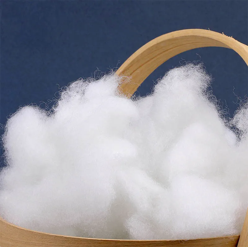 Soft white polyester fiberfill in a wooden basket for stuffing plush toys
