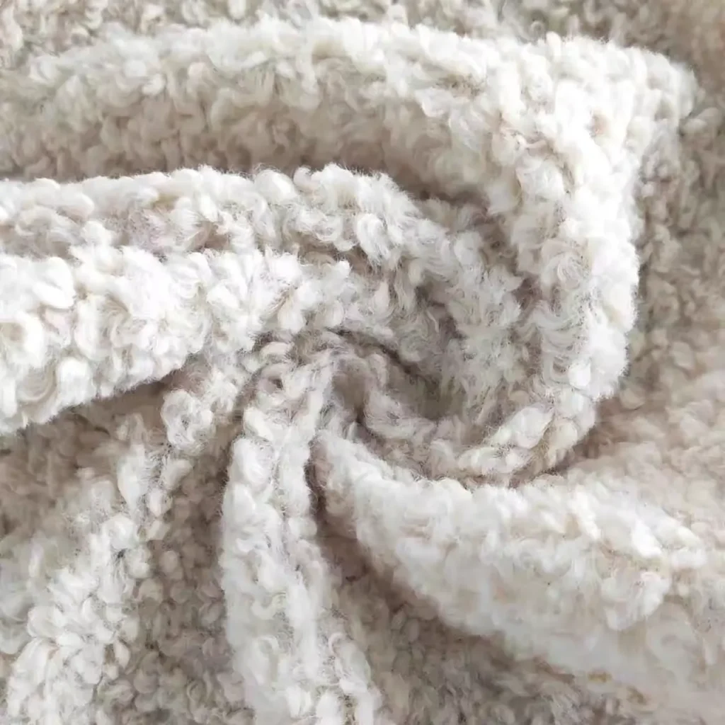 Detailed view of soft and textured cream sherpa fleece fabric with curly pile surface, ideal for winter coats and plush toys.